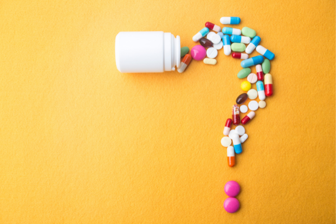 Photo of white pill jar spilling out different coloured pills into the shape of a question mark on a yellow background. Photo credit: Canva Plus