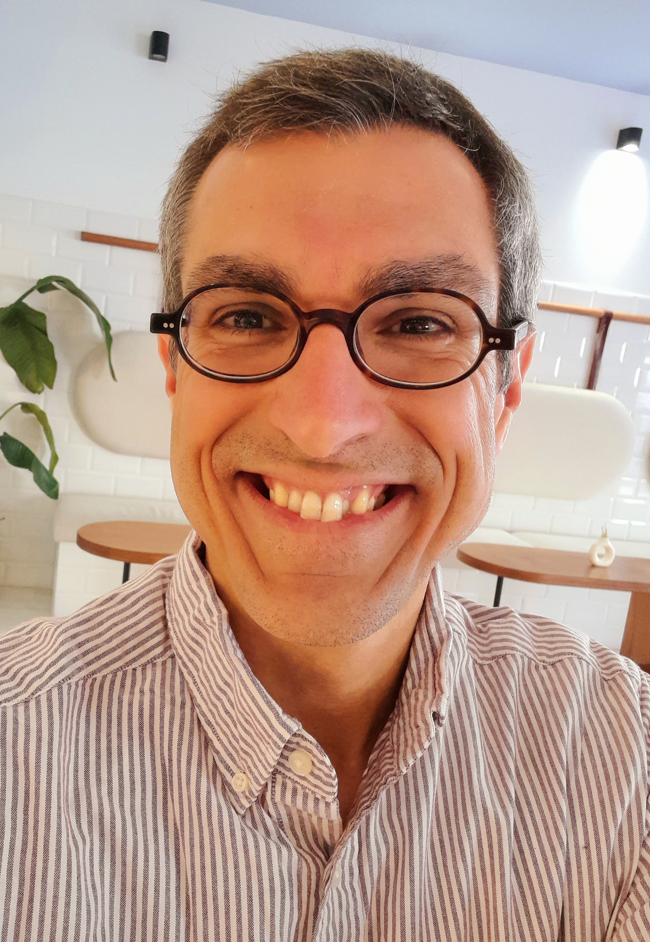 A photo of Chris, a white man with salt-and-pepper coloured hair and wearing glasses.