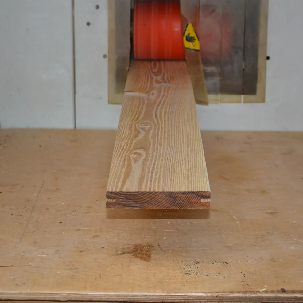 Black locust board being hand-graded and finished on the bandsaw to match order specifications