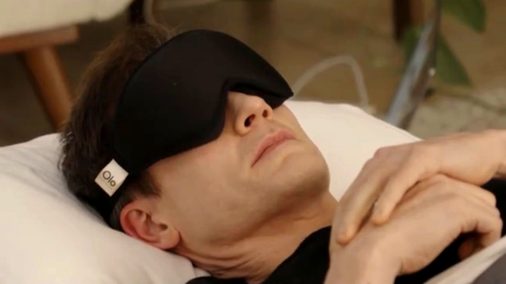 Bryan Johnson lying down wearing the Black Olo eye mask during a livestream