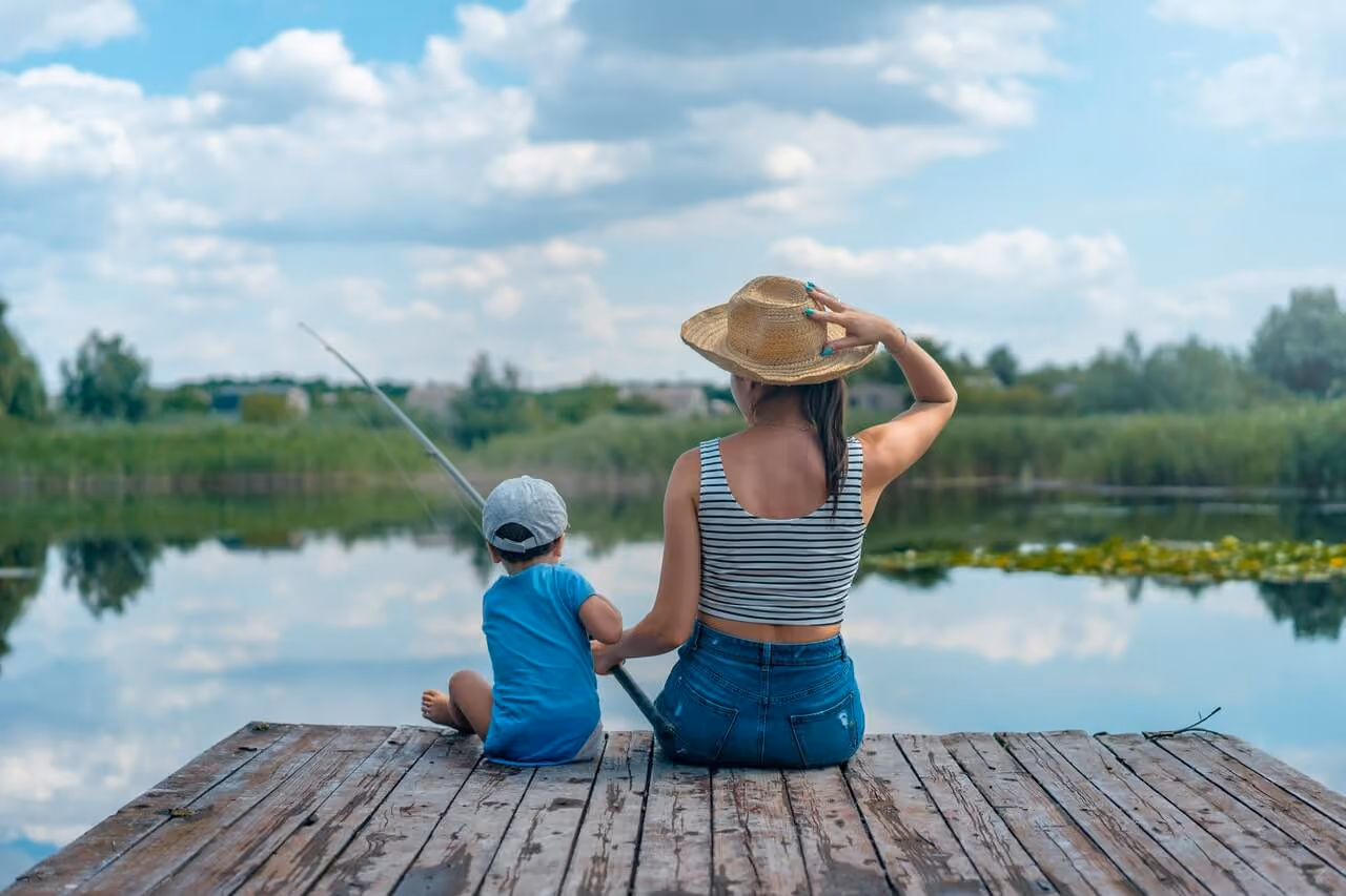 A mother and son sitting on a pier fishing