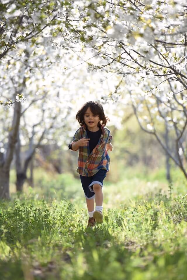 A young boy running through grass