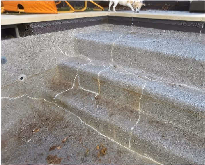 Close-up of an ASR crack in concrete with temporary patch putty applied to prevent further damage. The image highlights the visible effects of Alkali-Silica Reaction (ASR) on pool surfaces.