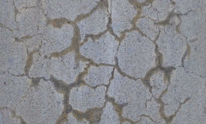 Close-up view of concrete showing visible cracks caused by Alkali-Silica Reaction (ASR), a chemical reaction that weakens concrete over time, leading to structural damage.