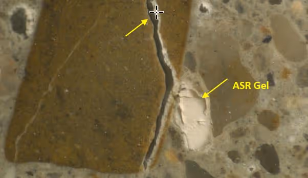 Close-up of an Alkali-Silica Reaction (ASR) crack in concrete, showing the gel formation within the crack caused by the chemical reaction, which contributes to further expansion and damage.