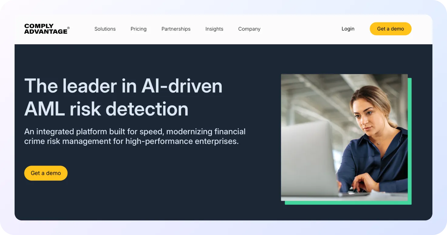 Página de inicio de ComplyAdvantage con el mensaje ‘The leader in AI-driven AML risk detection’, mostrando una plataforma de detección de riesgos AML basada en inteligencia artificial y una profesional trabajando frente a un ordenador portátil.