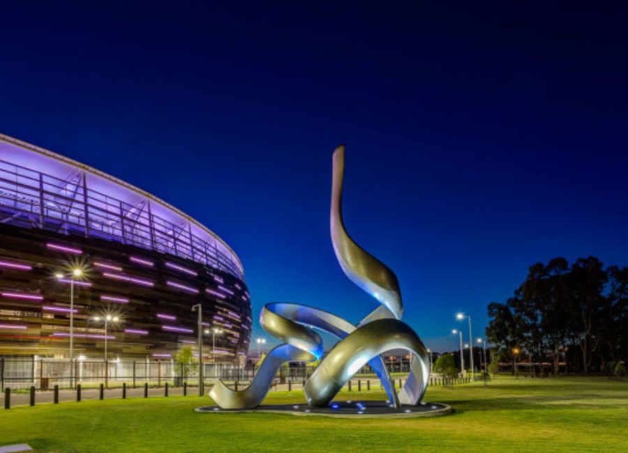 Convergence sculpture by Jon Tarry. A metallic sculpture of interwoven curves at Perth Stadium.