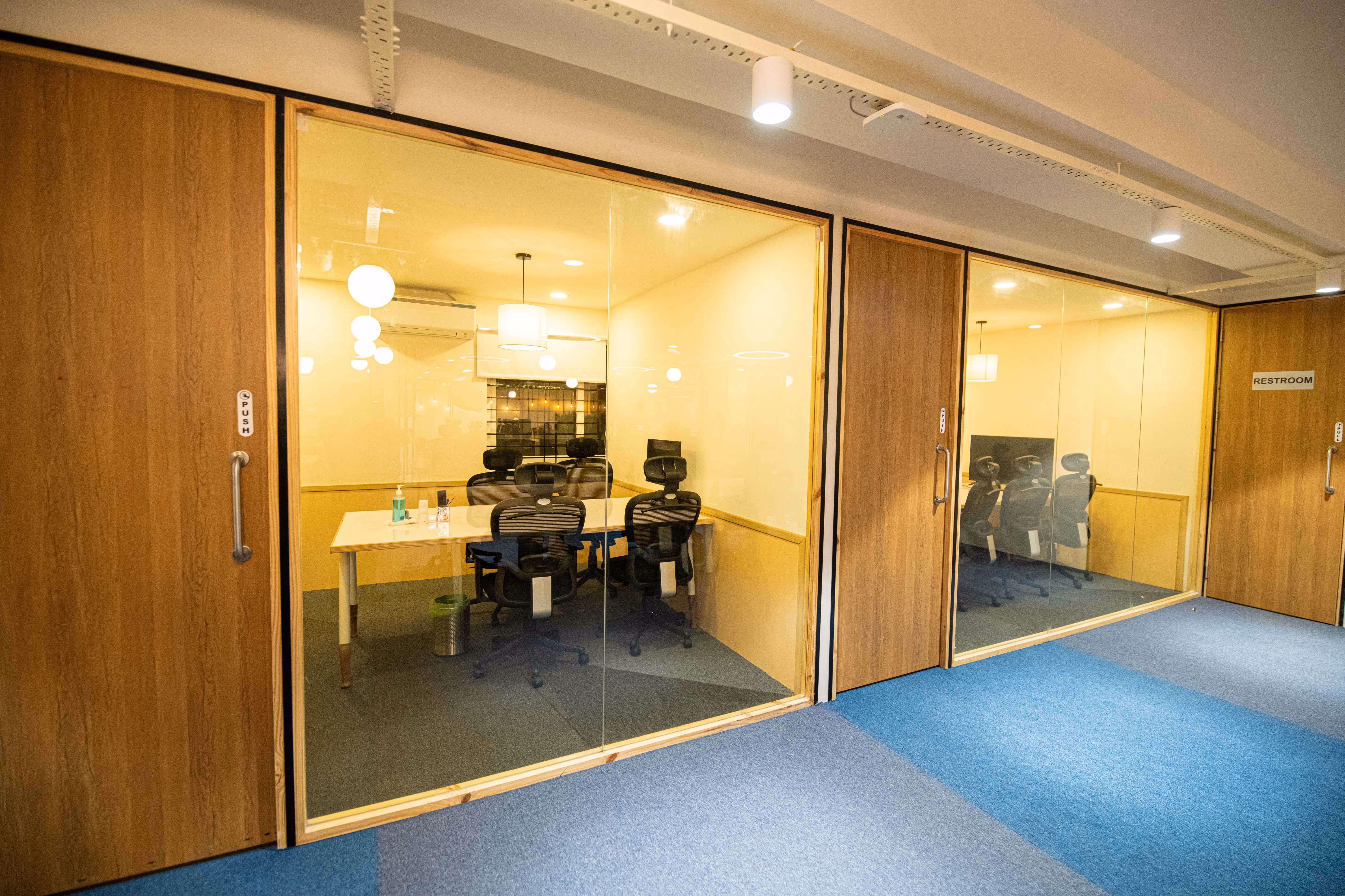 Glass-fronted meeting rooms with wood doors at Urban Vault