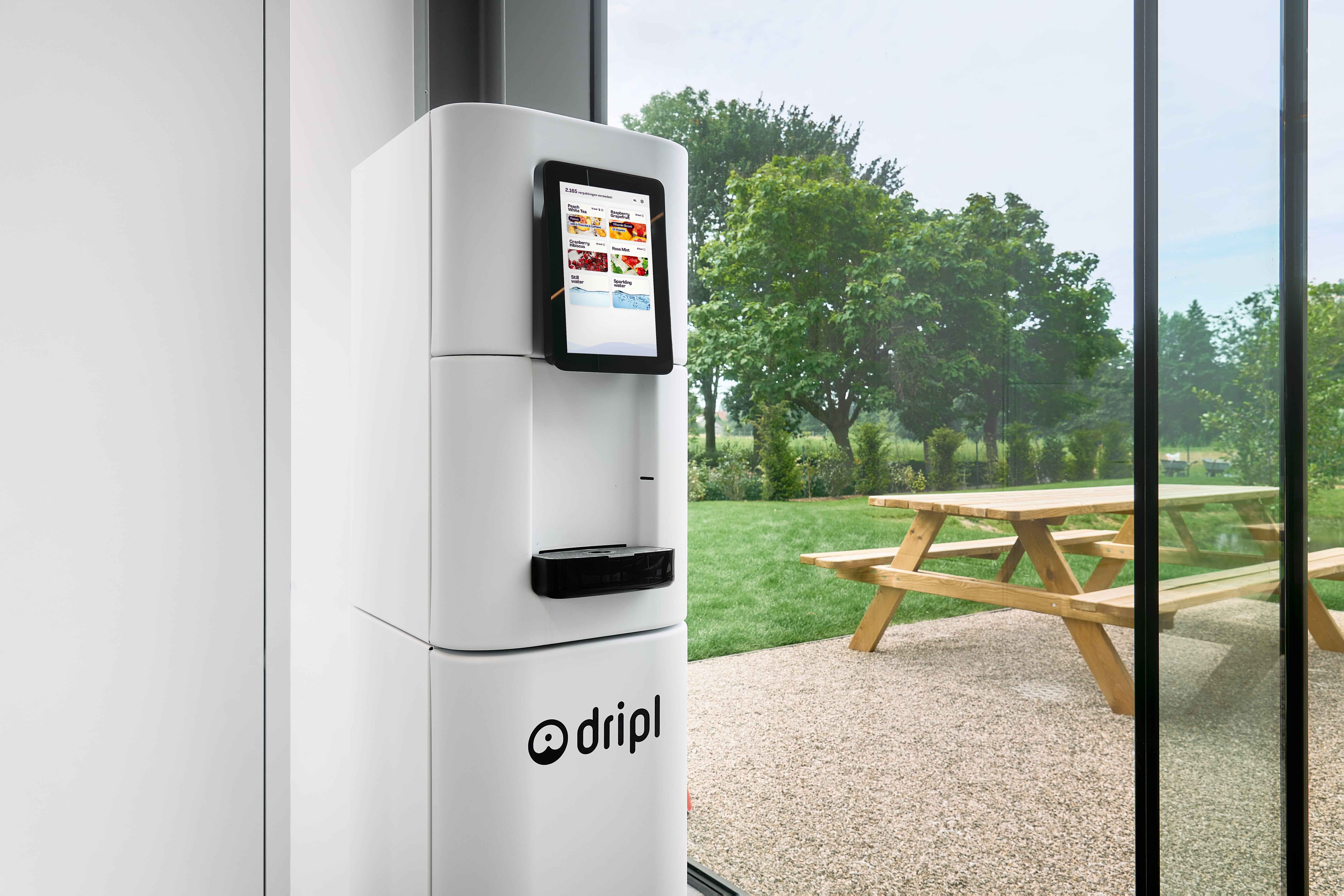 Dripl Refill Point in an office kitchen overlooking a green garden setting.