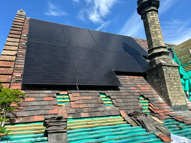 Black solar panels in the process of being installed on a installed on shingled roof
