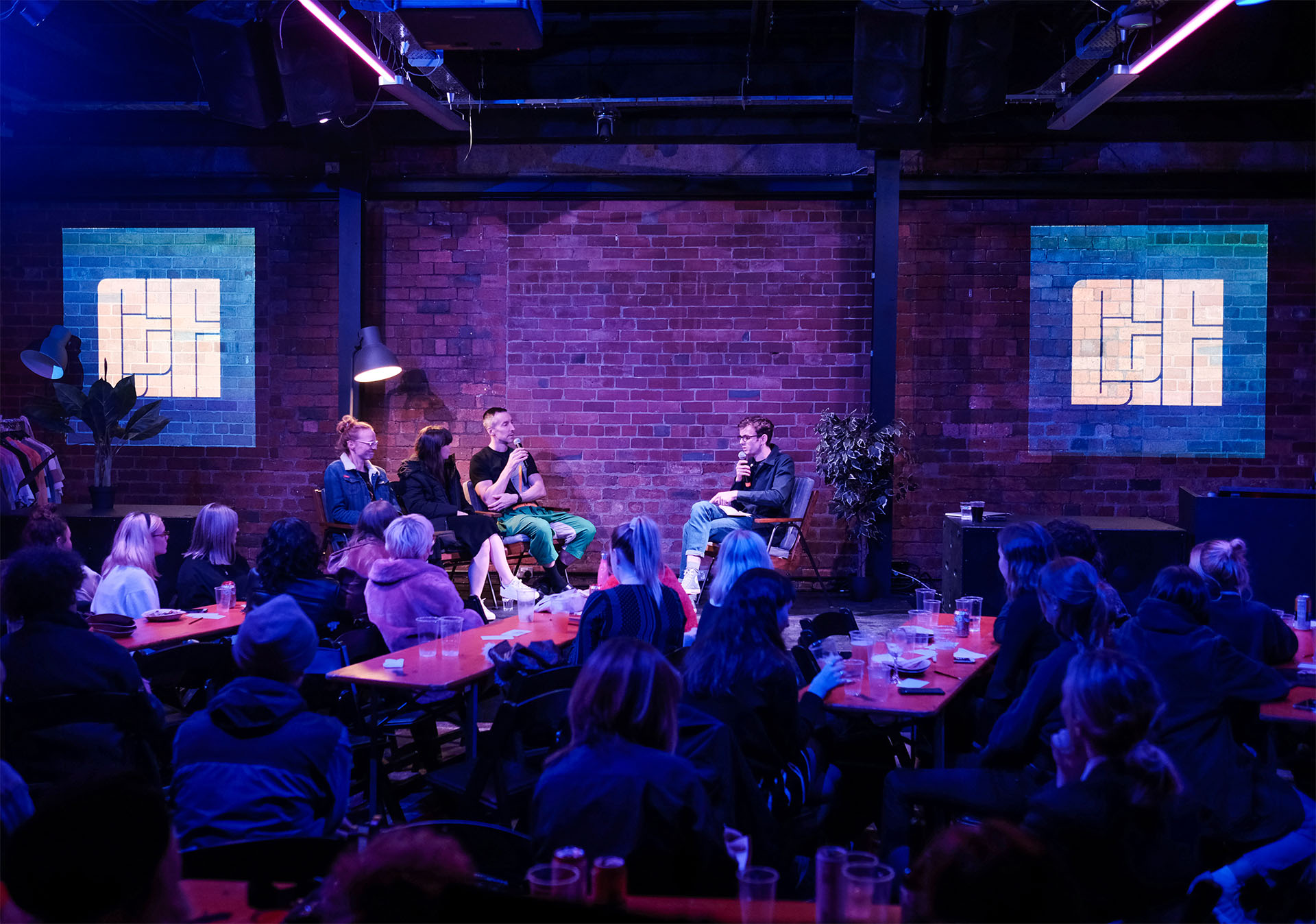 Audience watching four people on a stage panel discussion.
