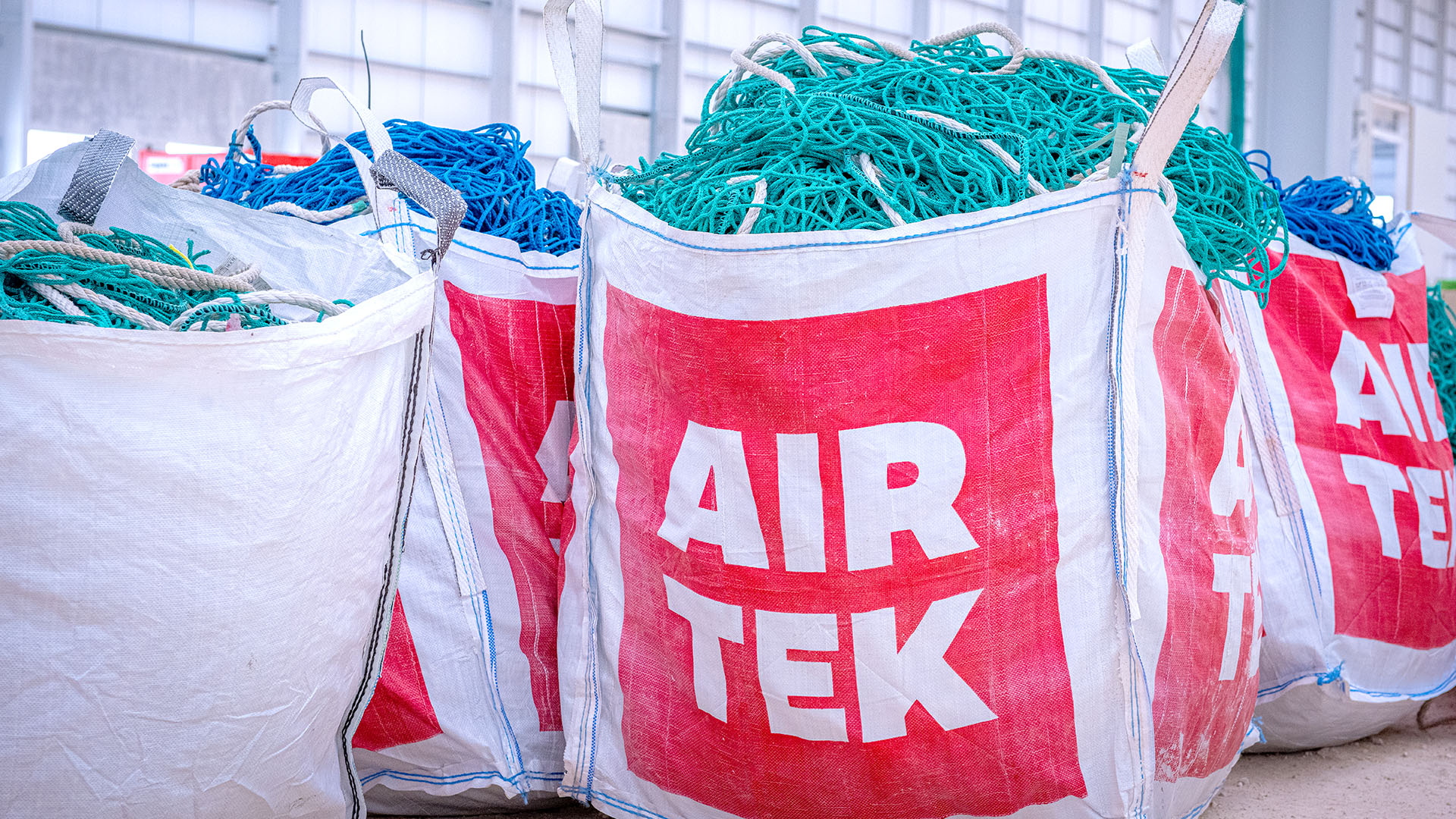 Large plastic bags containing safety netting, with the Airtek logo on them.