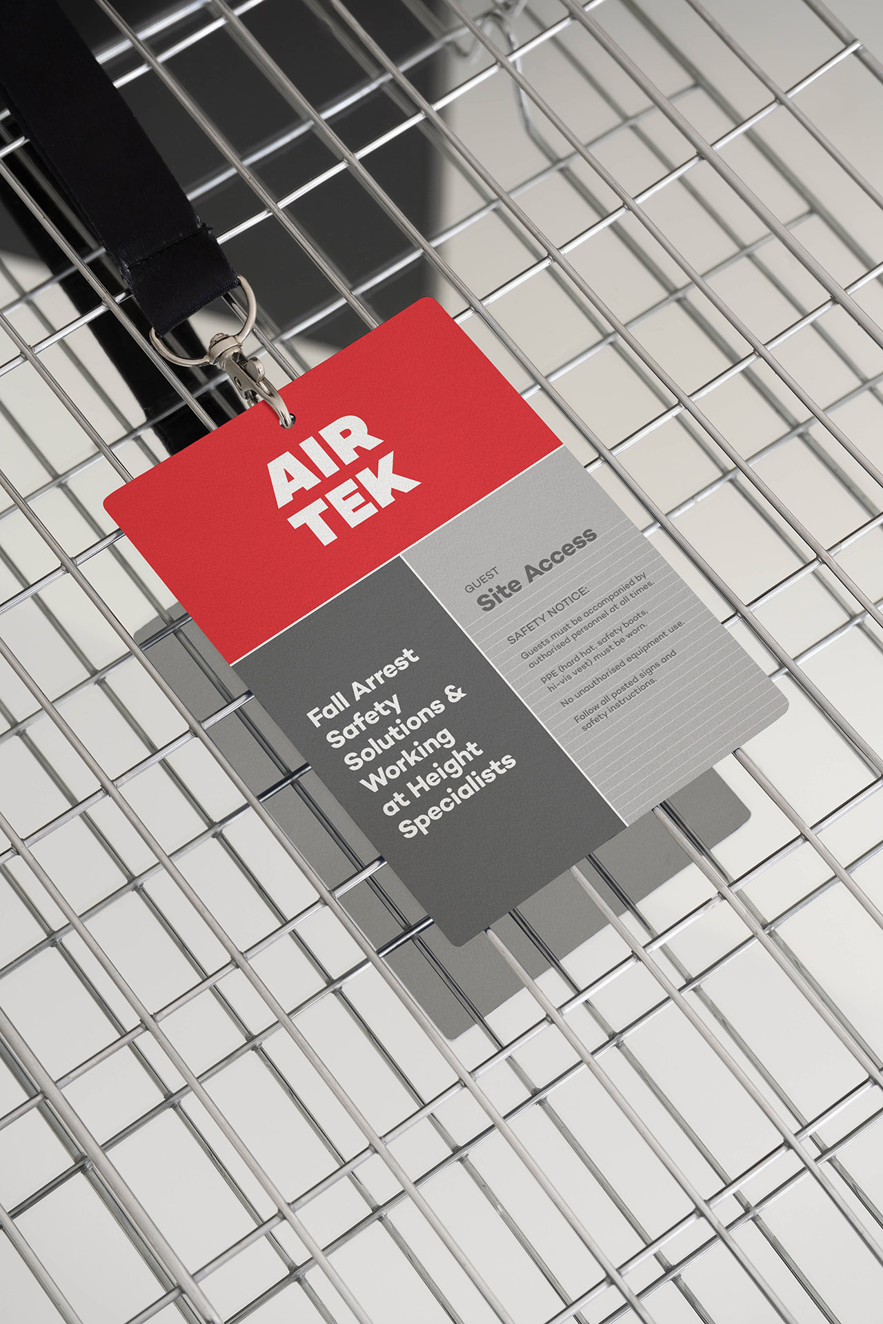 An Airtek guest pass on a lanyard sits on top of a metal grid.