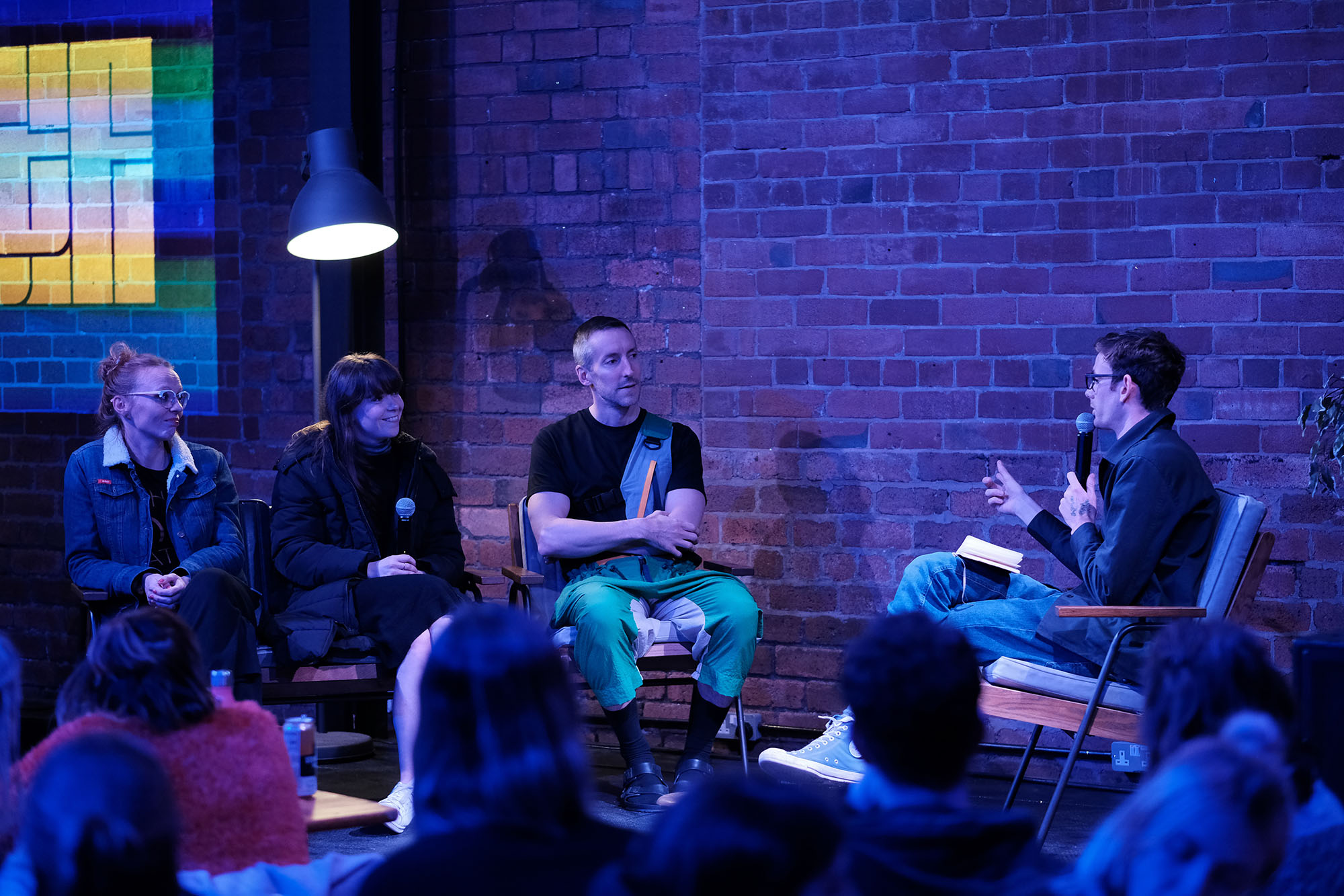 Audience watches a four-person panel discussion on stage.