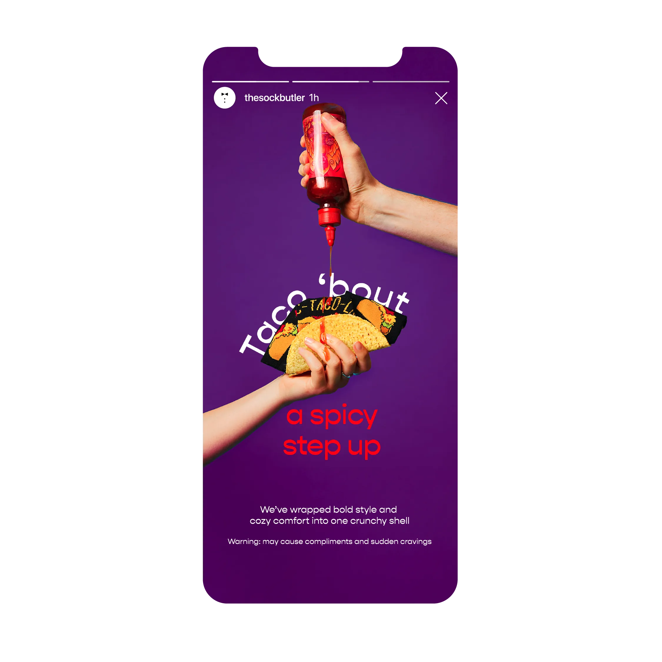 Phone showing The Sock Butler Instagram story: hand holding taco socks in a taco shell, reading 'Taco 'bout a spicy step up,' on a purple background, while another hand squeezes hot sauce onto it.
