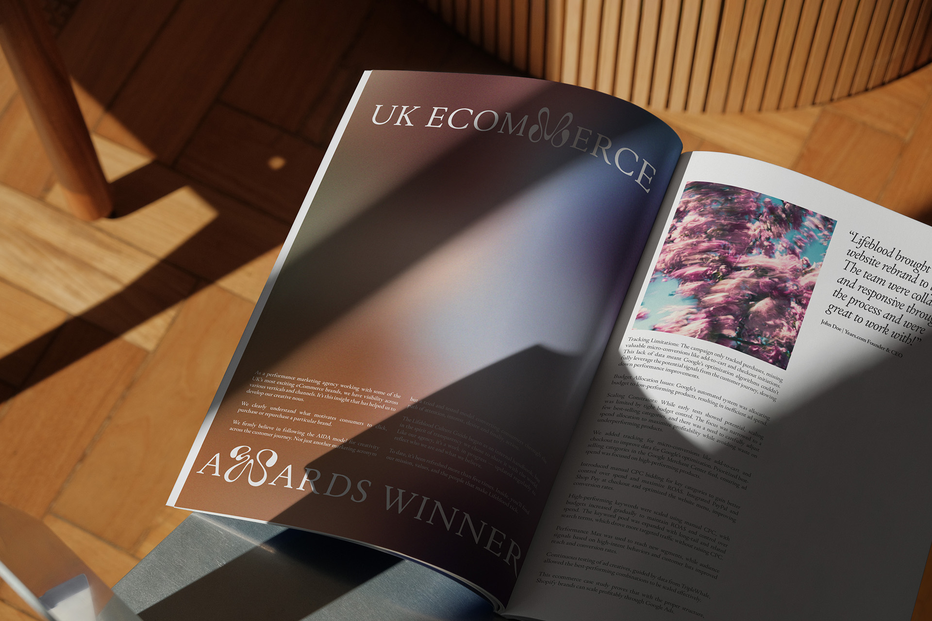 Close-up of a brochure on a table, showing a double-page editorial layout with text and images.