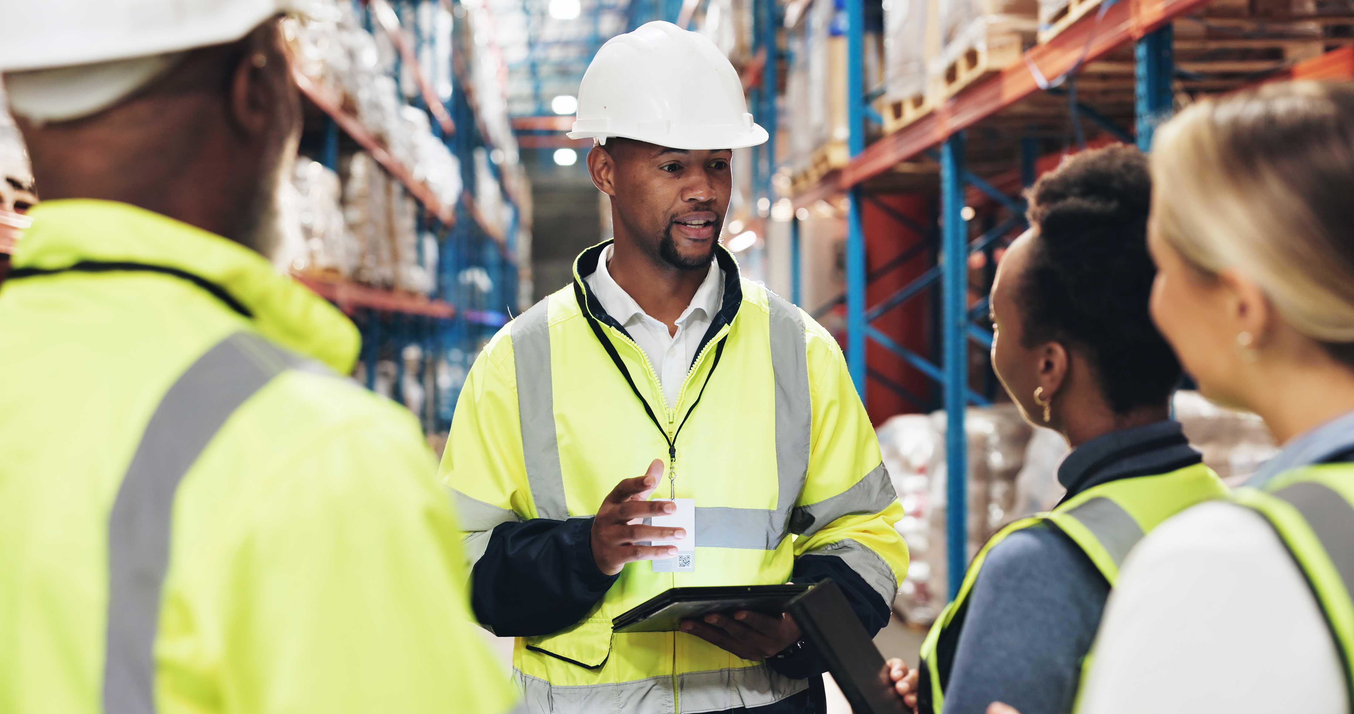A guy talking to three other people in safety gear