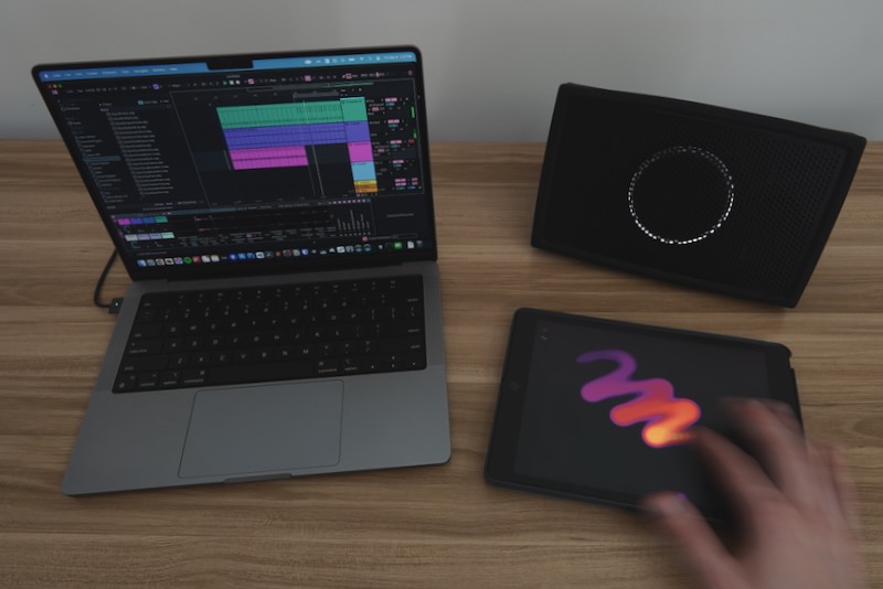 hand touching ipad next to mac