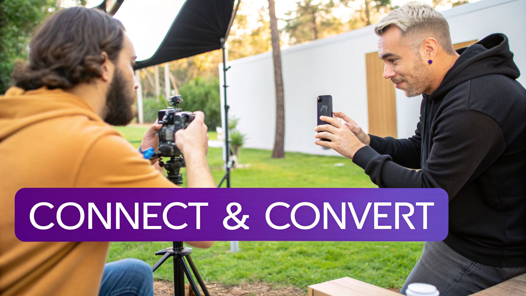 Two men creating social media content outdoors, one filming with a camera, the other holding a smartphone.