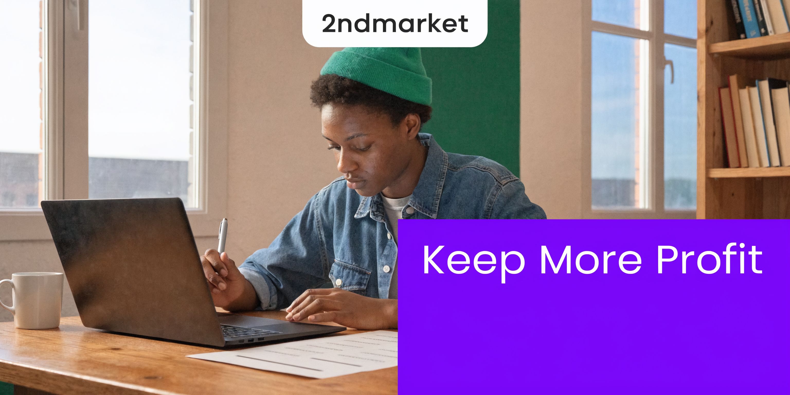 A person in a green beanie working on a laptop at a desk with a coffee mug.