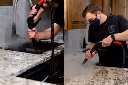 Person using a steam cleaner to clean a kitchen countertop wearing a mask.