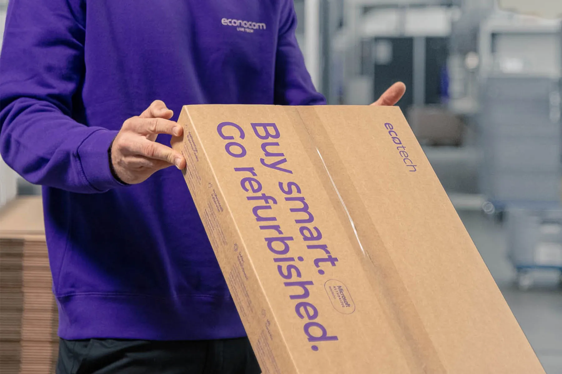 Ein Mitarbeiter hält ein Ecotech-Paket in seinen Händen.