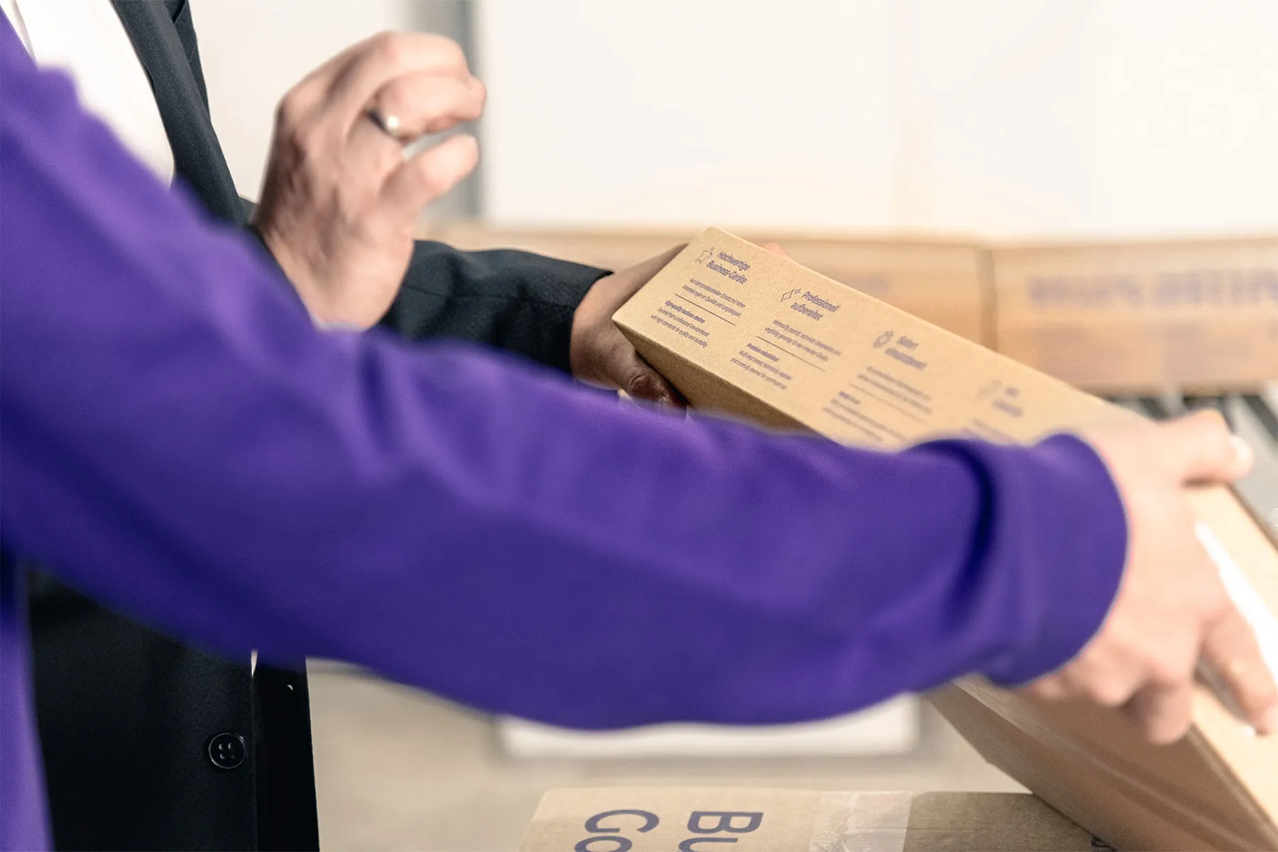 Ein Mitarbeiter hält ein Paket in der Hand.