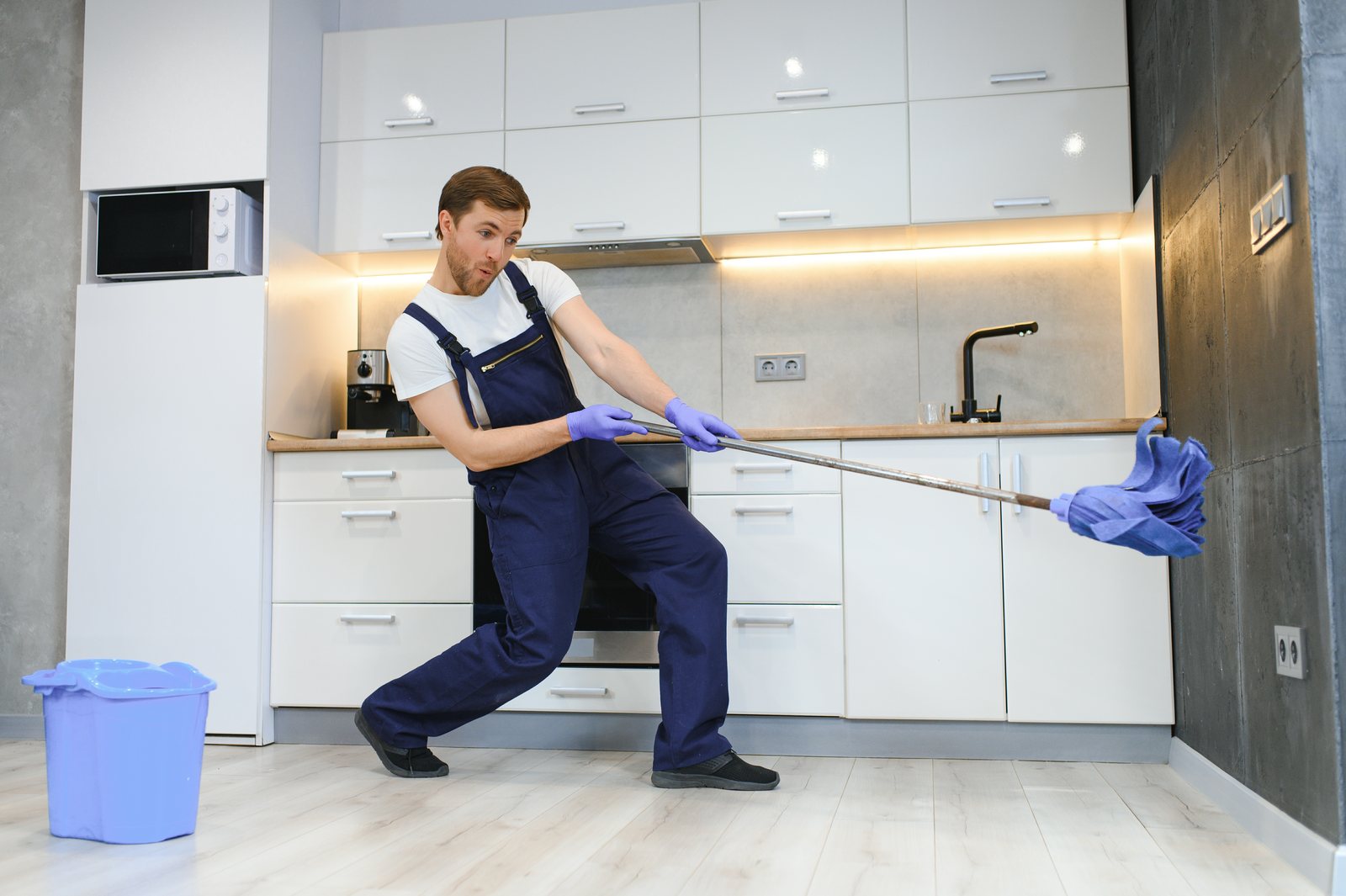 Professional cleaner mopping an empty apartment before move-in