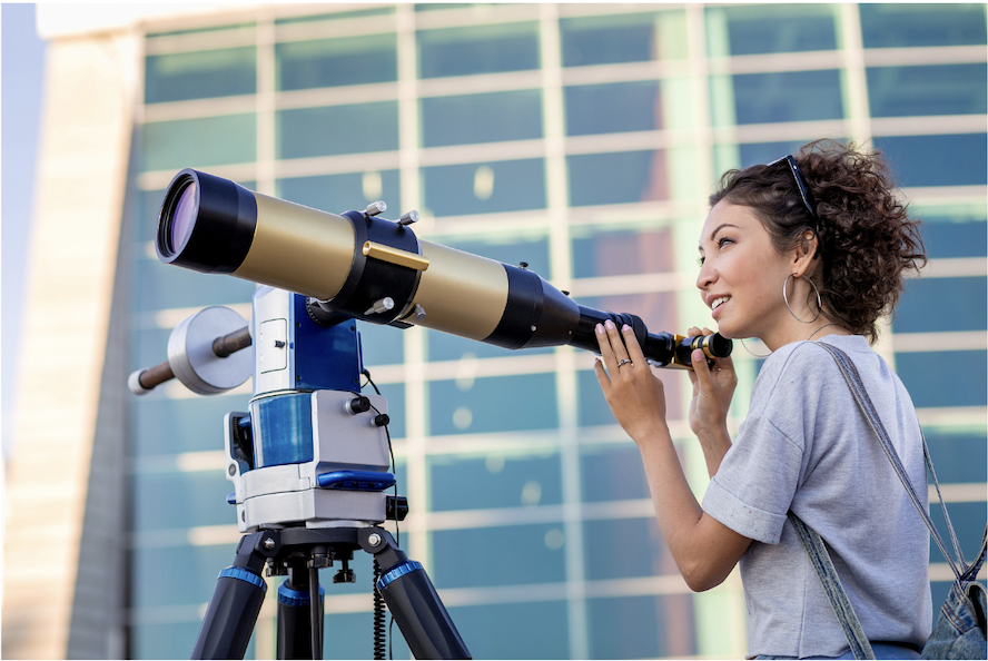 Woman looking through telescope representing strategic horizon scanning