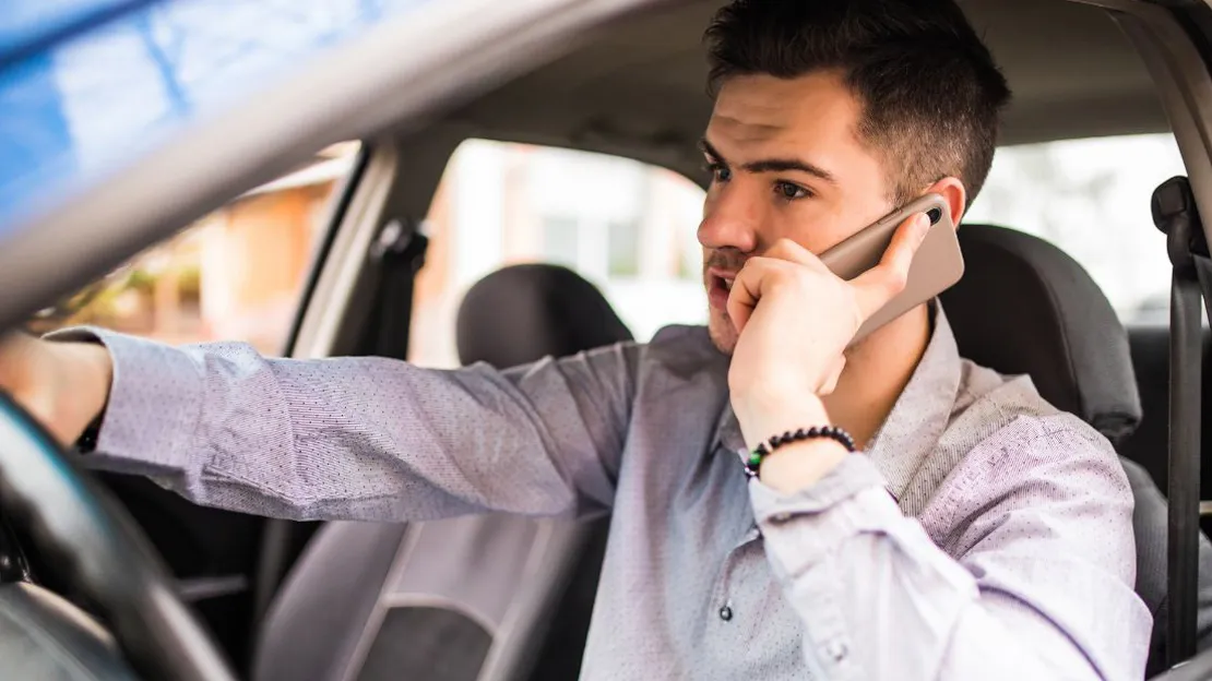An image of a driving using his cellphone while driving.