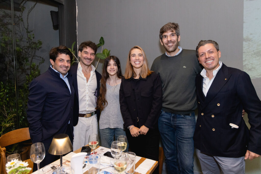 A group of six guests posing outside at the evening event.