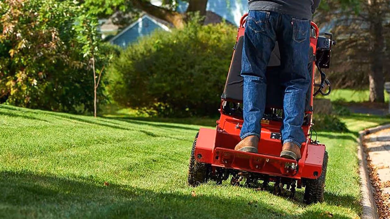 Lawn aerator on fresh green lawn handling core aeration for spring bloom.