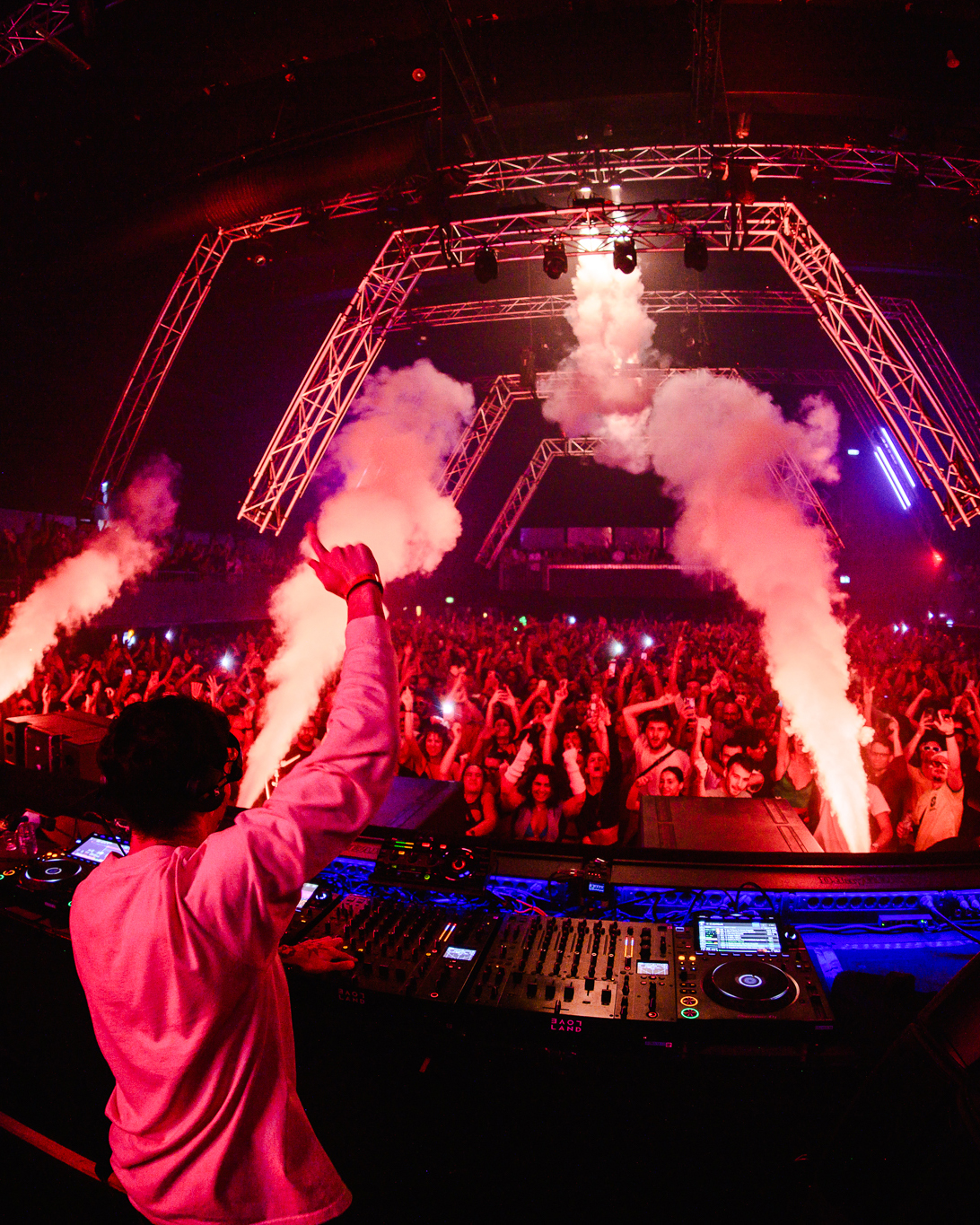 Crowd and DJ booth under red lighting at Loveland ADE