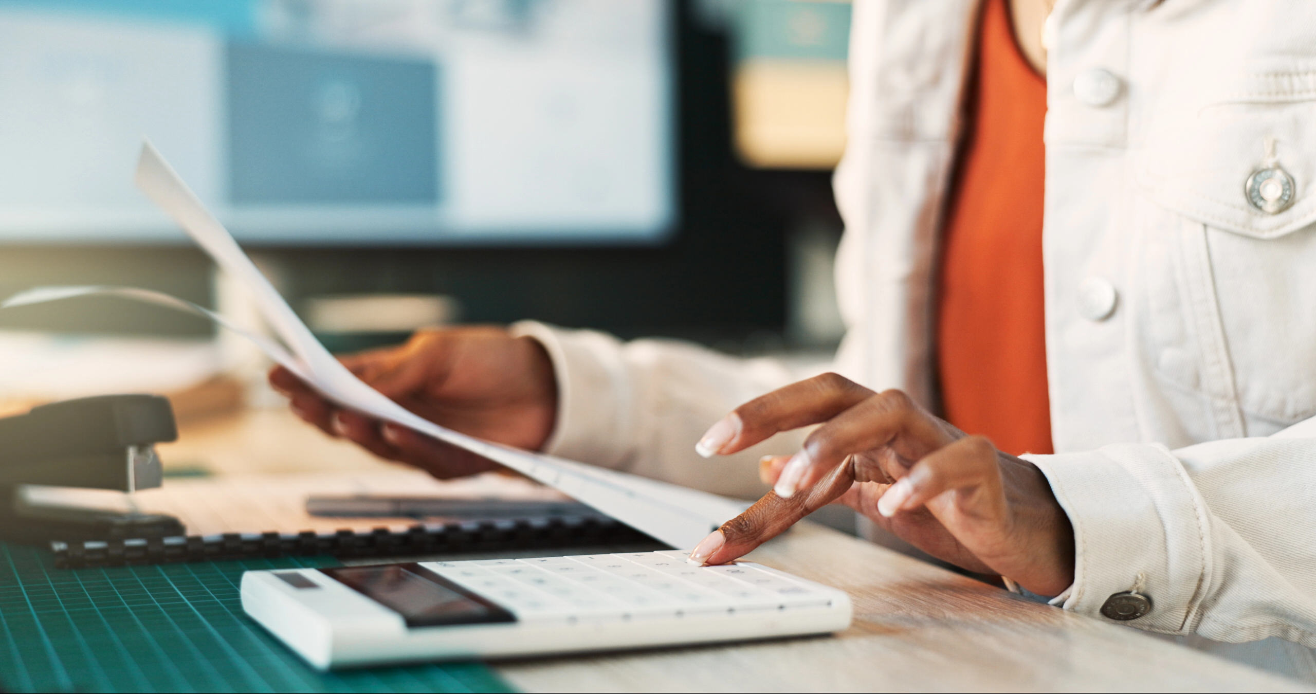 Professional working at desk with documents and calculator