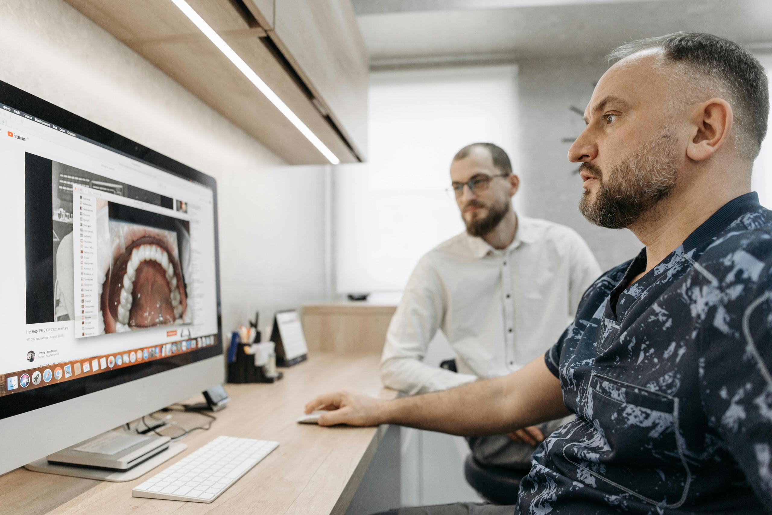 Dental professionals reviewing teeth scan on computer in modern office