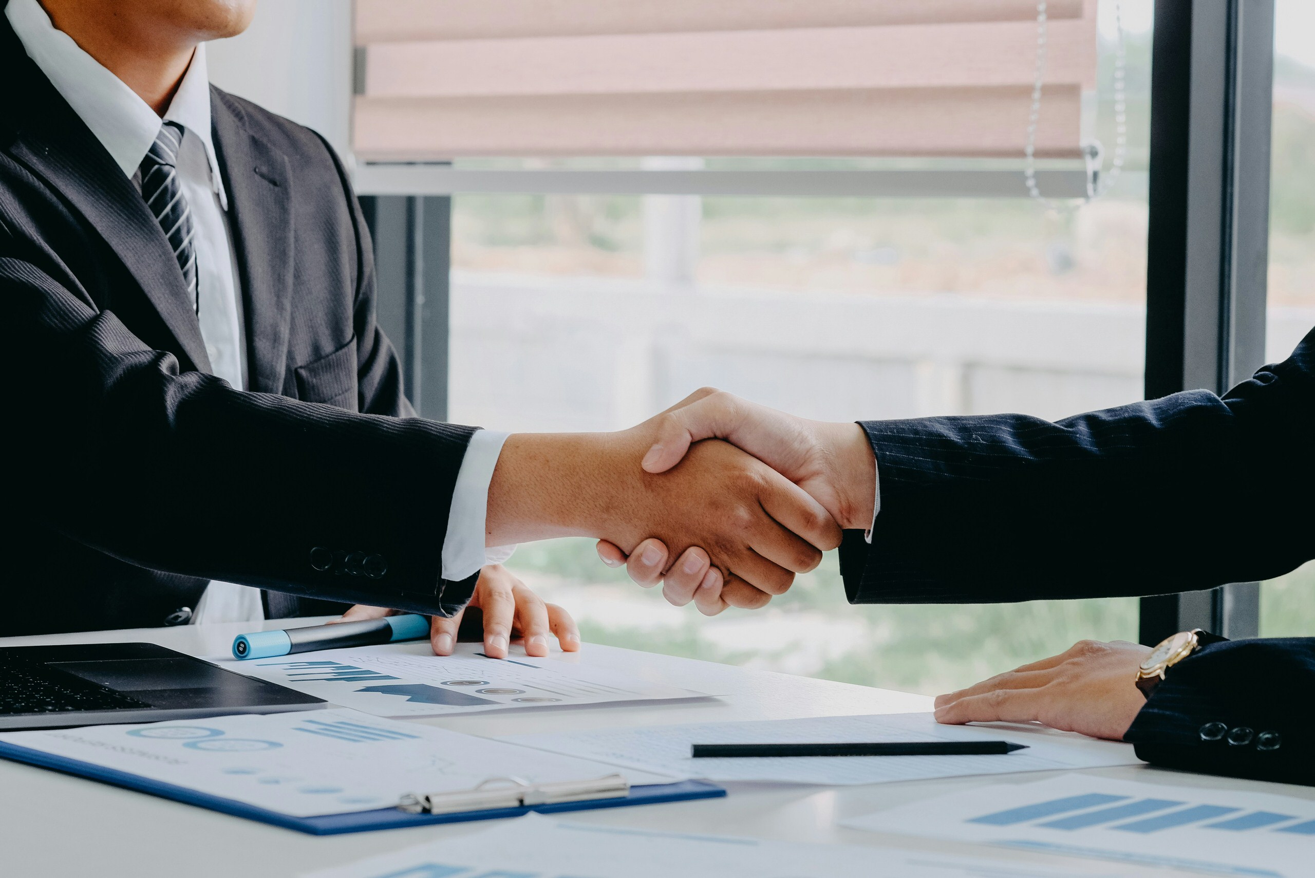 Two men shaking hands after finalizing a sale of a dental practice