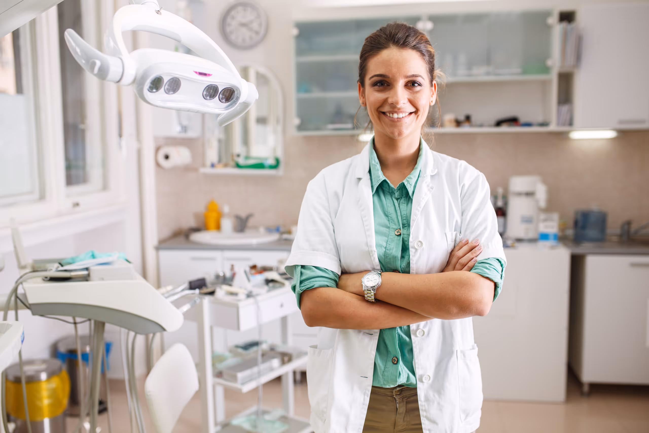 A young female dentist standing proudly in an operatory of her new dental practice