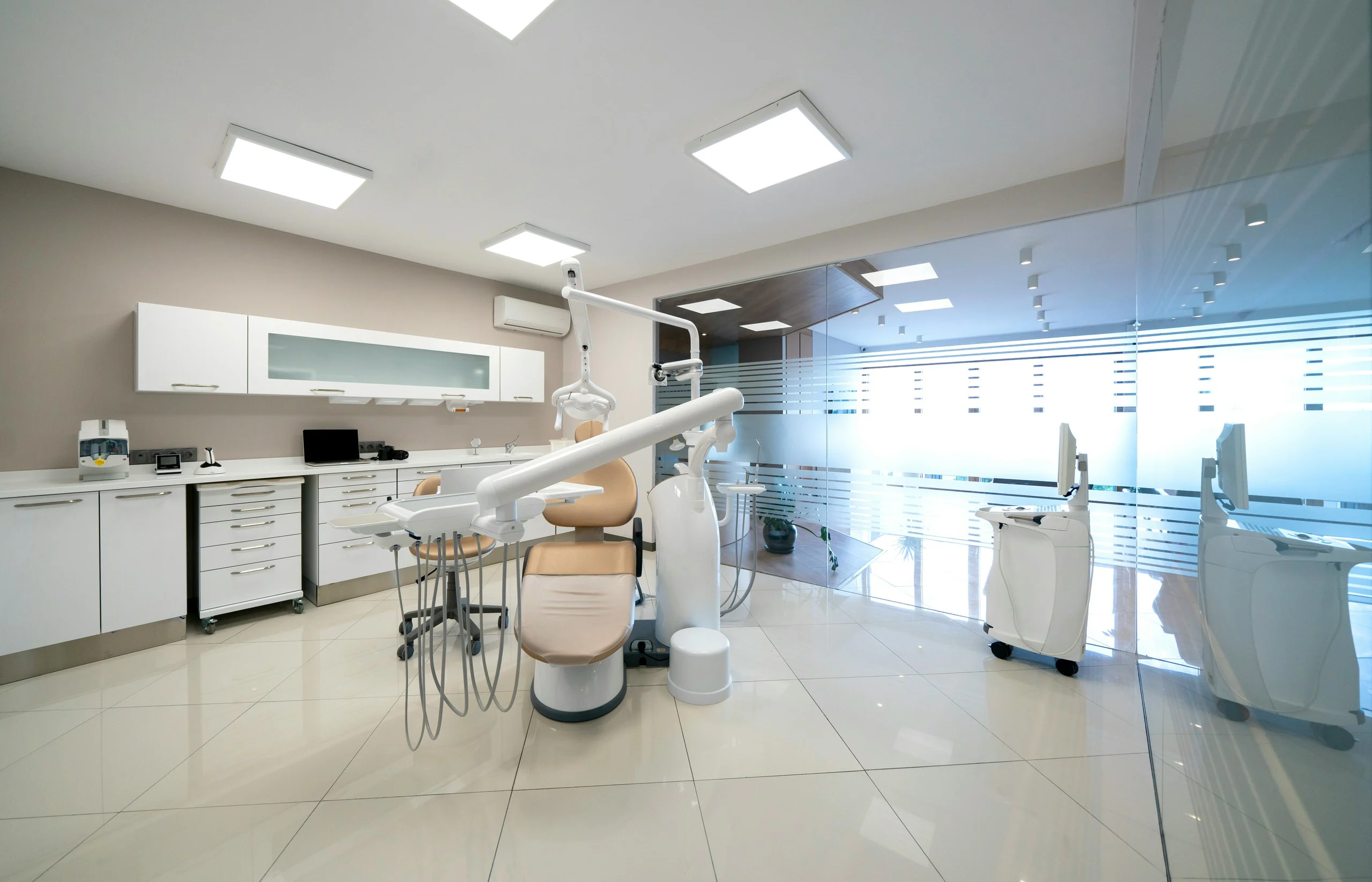 Modern, clean dental office with white chair and medical equipment