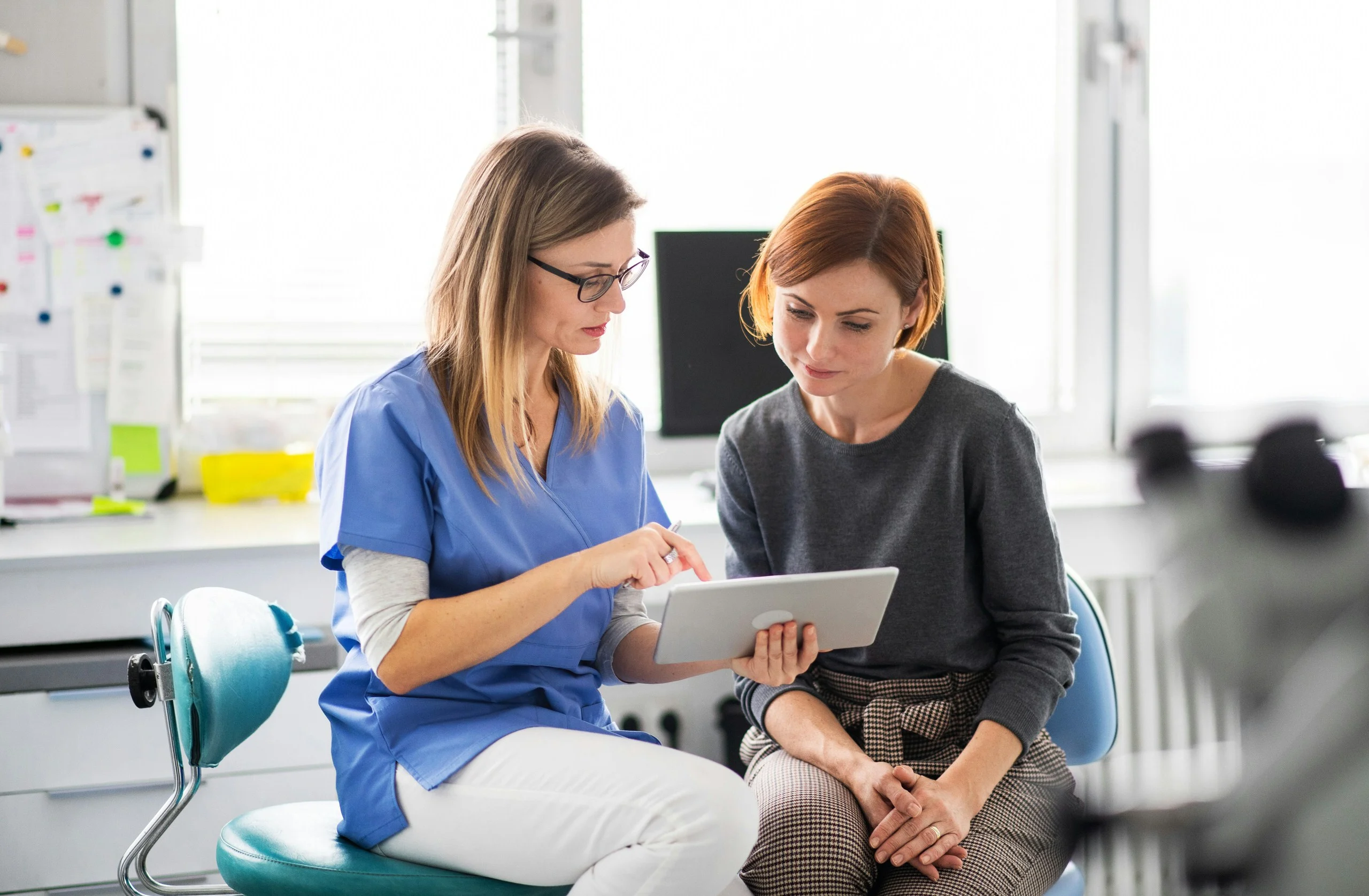 Healthcare professional and patient reviewing information on tablet together