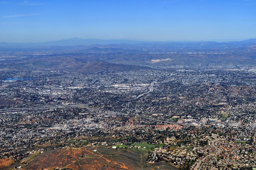 Aerial view of sprawling urban landscape with mountains in background