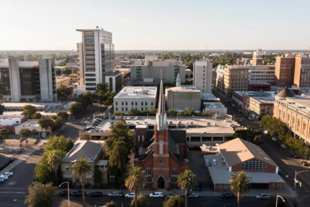 Aerial view of urban city center with church, buildings, and palm trees