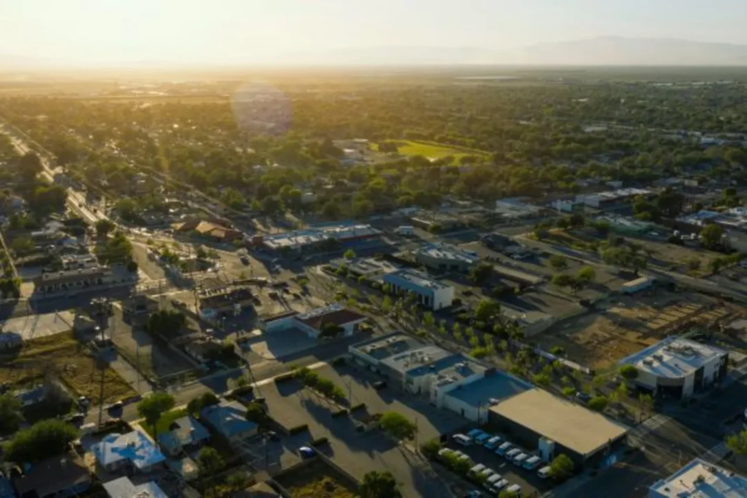 Aerial view of suburban town at golden sunset with trees and buildings