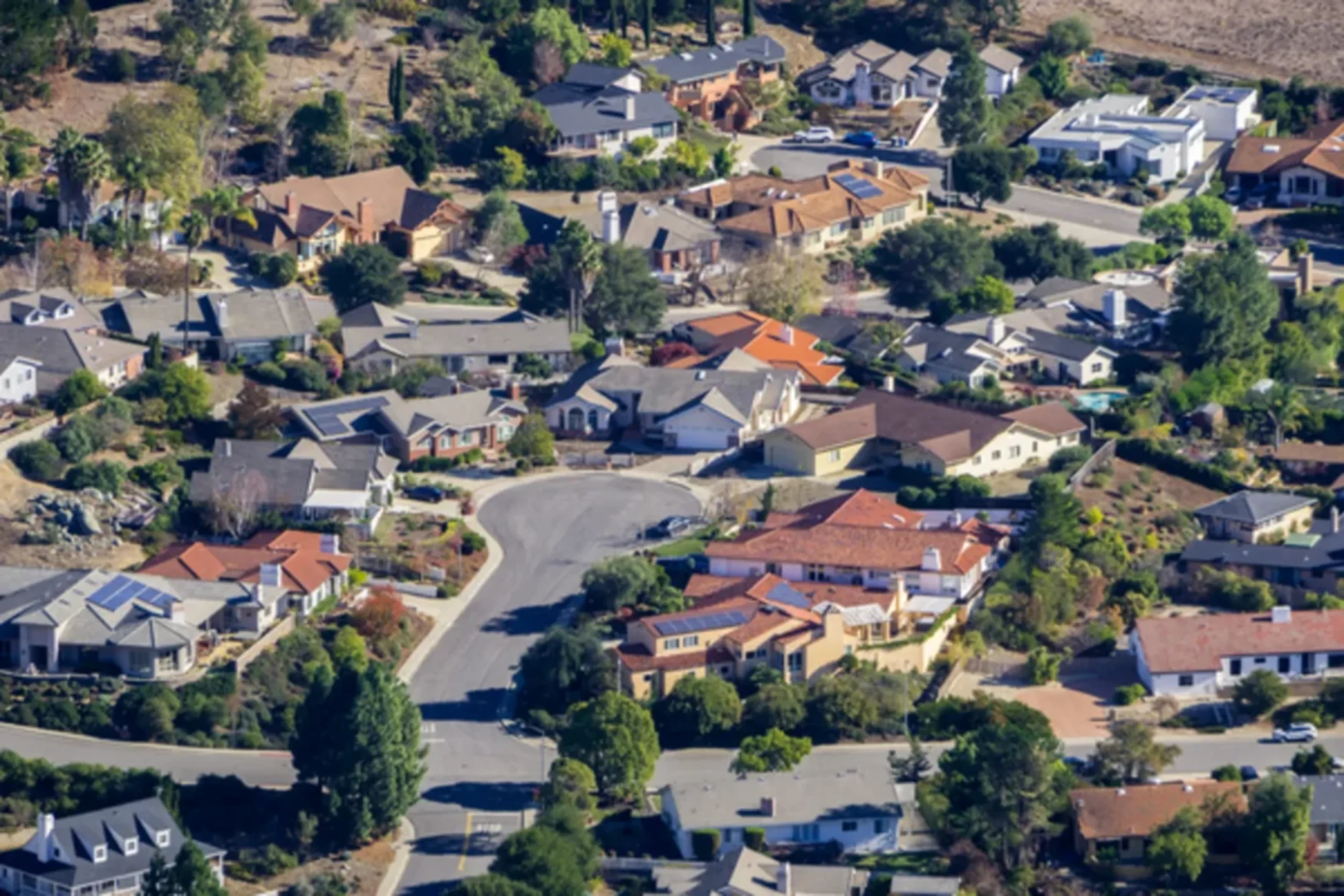 Aerial view of suburban neighborhood with diverse houses and winding streets