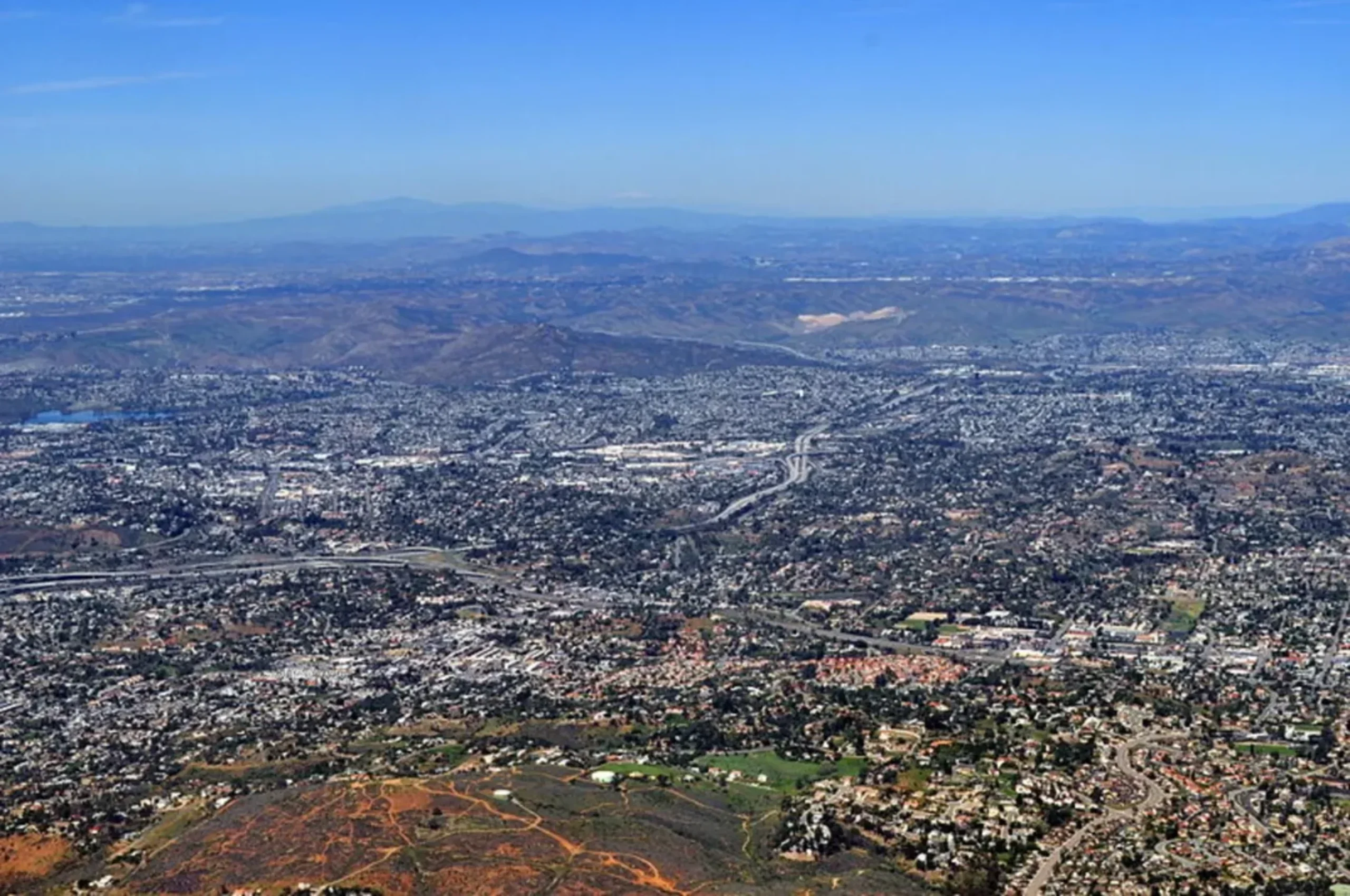 Aerial view of sprawling urban landscape with mountains in background