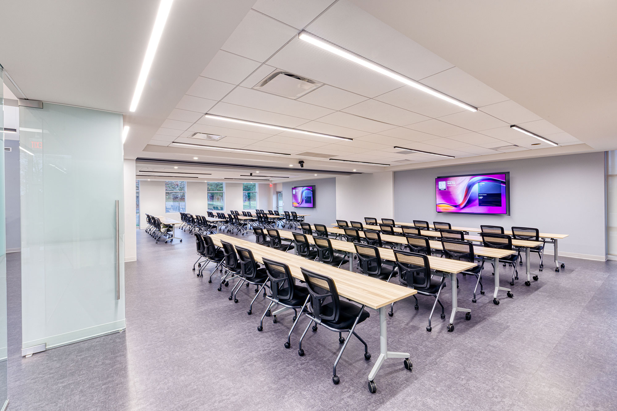 Flexible training room at Crowder Construction Expansion by Ossa Studio with rolling desks, integrated screens, and a movable wall system for space division.