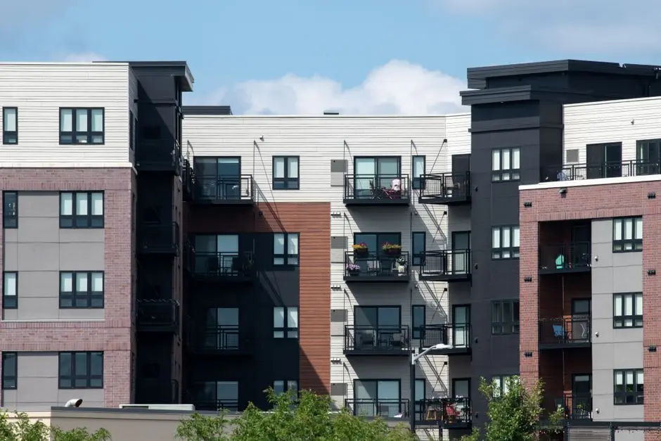 Contemporary apartment complex with diverse facade design in a sunny urban setting.