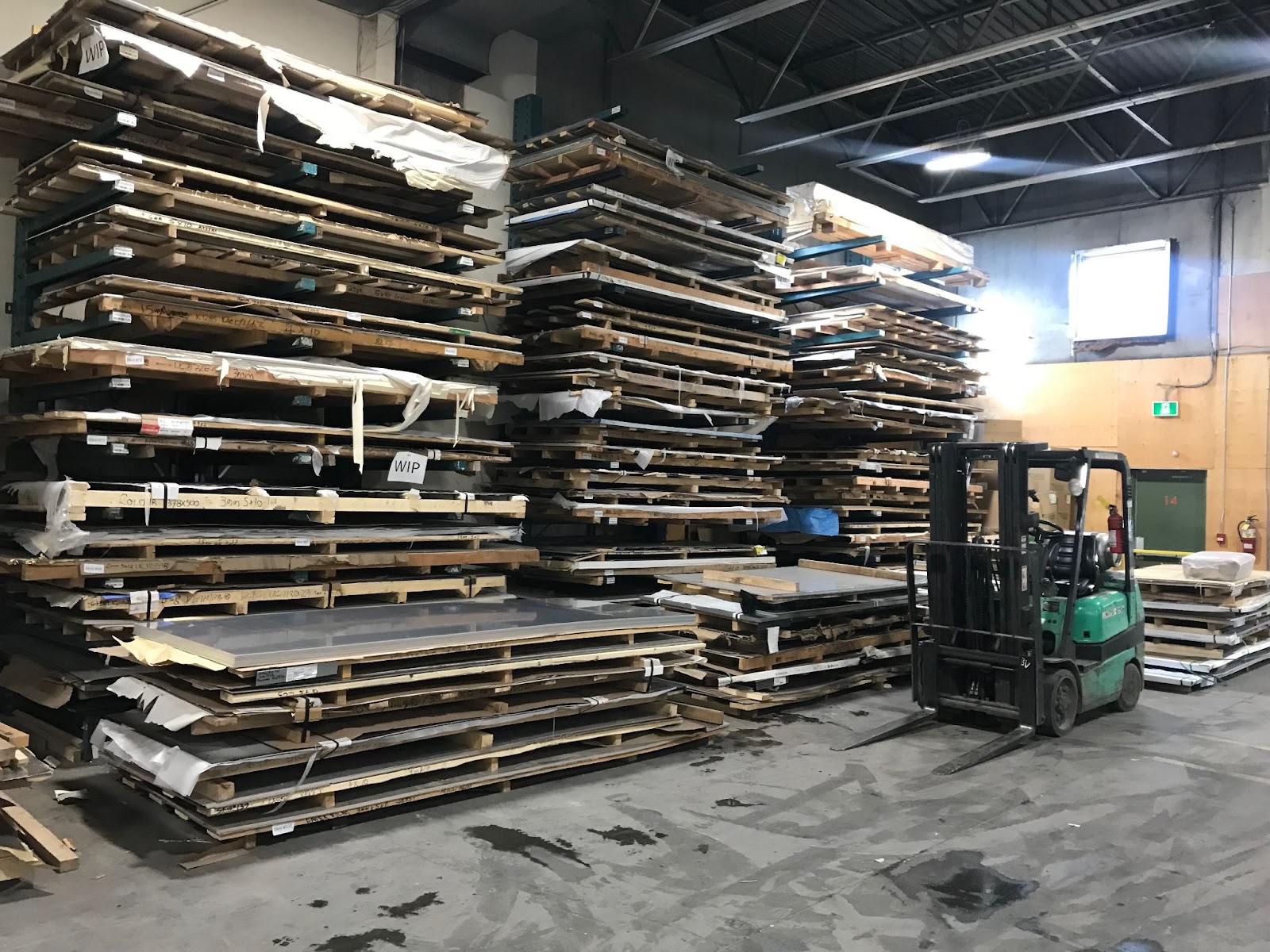 Wooden pallets in manufacturing facility stacked on top of one another, creating an inefficient process. 