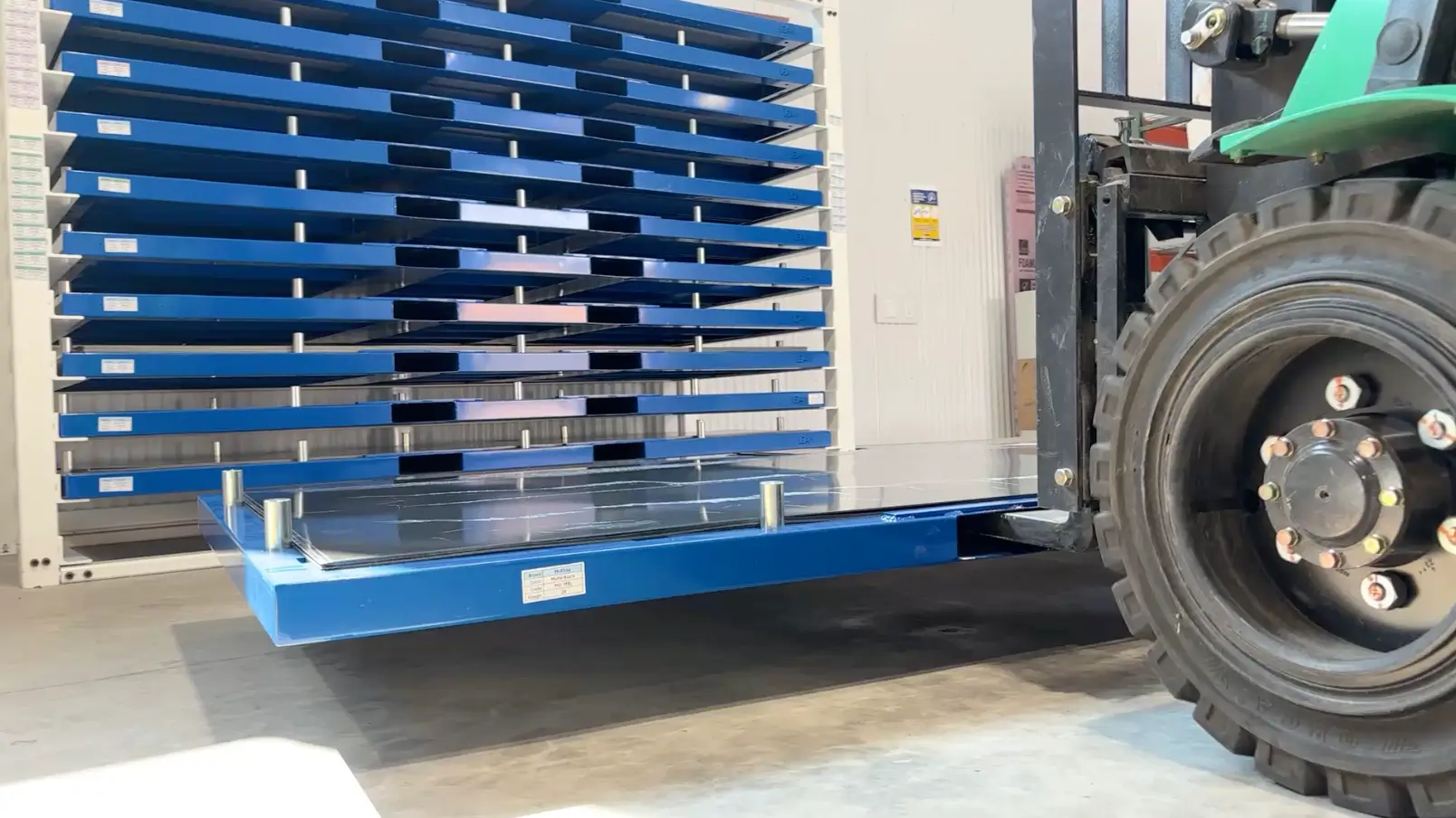 forklift operator inserting cartridge into a sheet metal storage rack