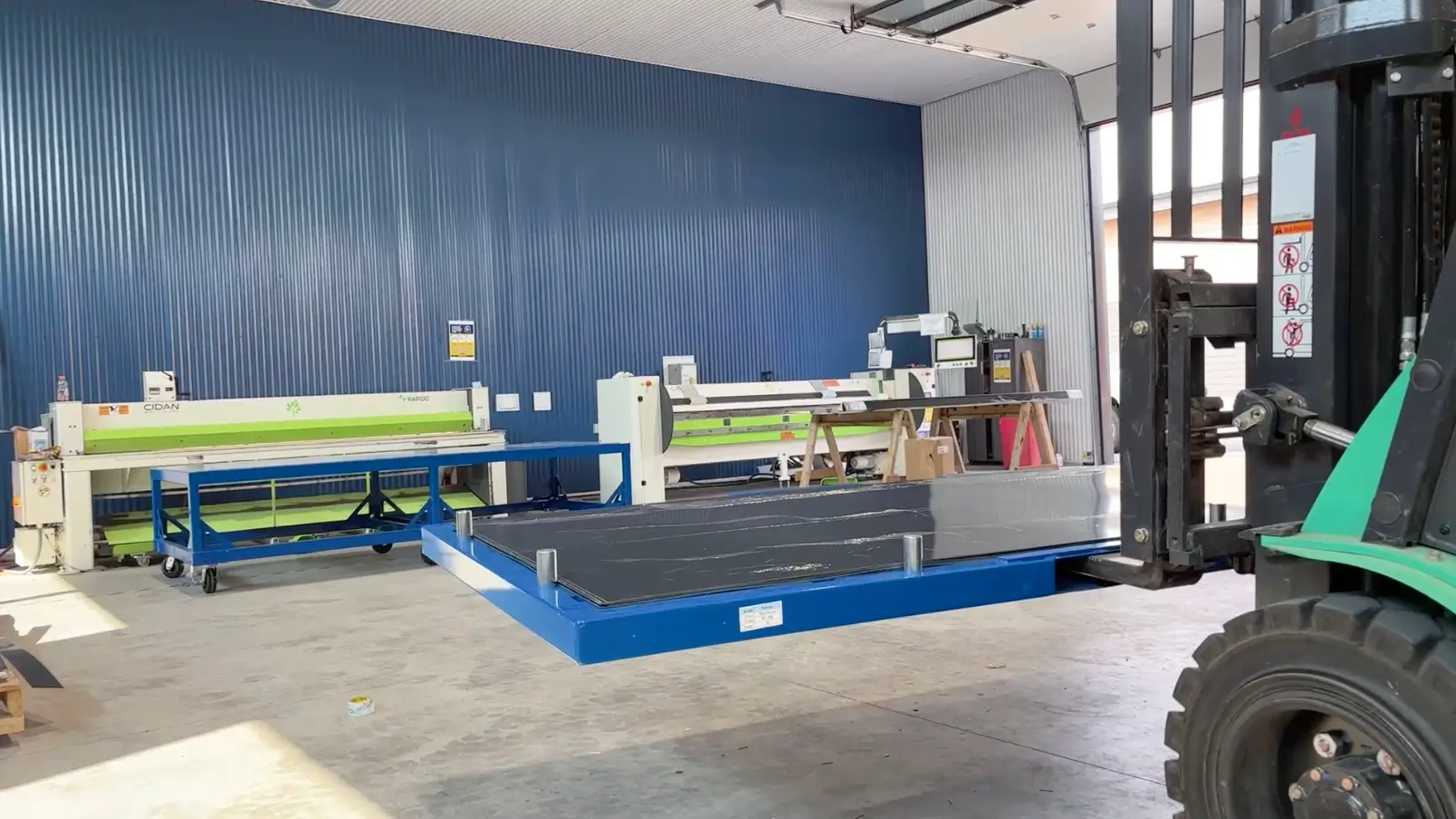 forklift placing returnable sheet metal storage cartridge onto pivot cart