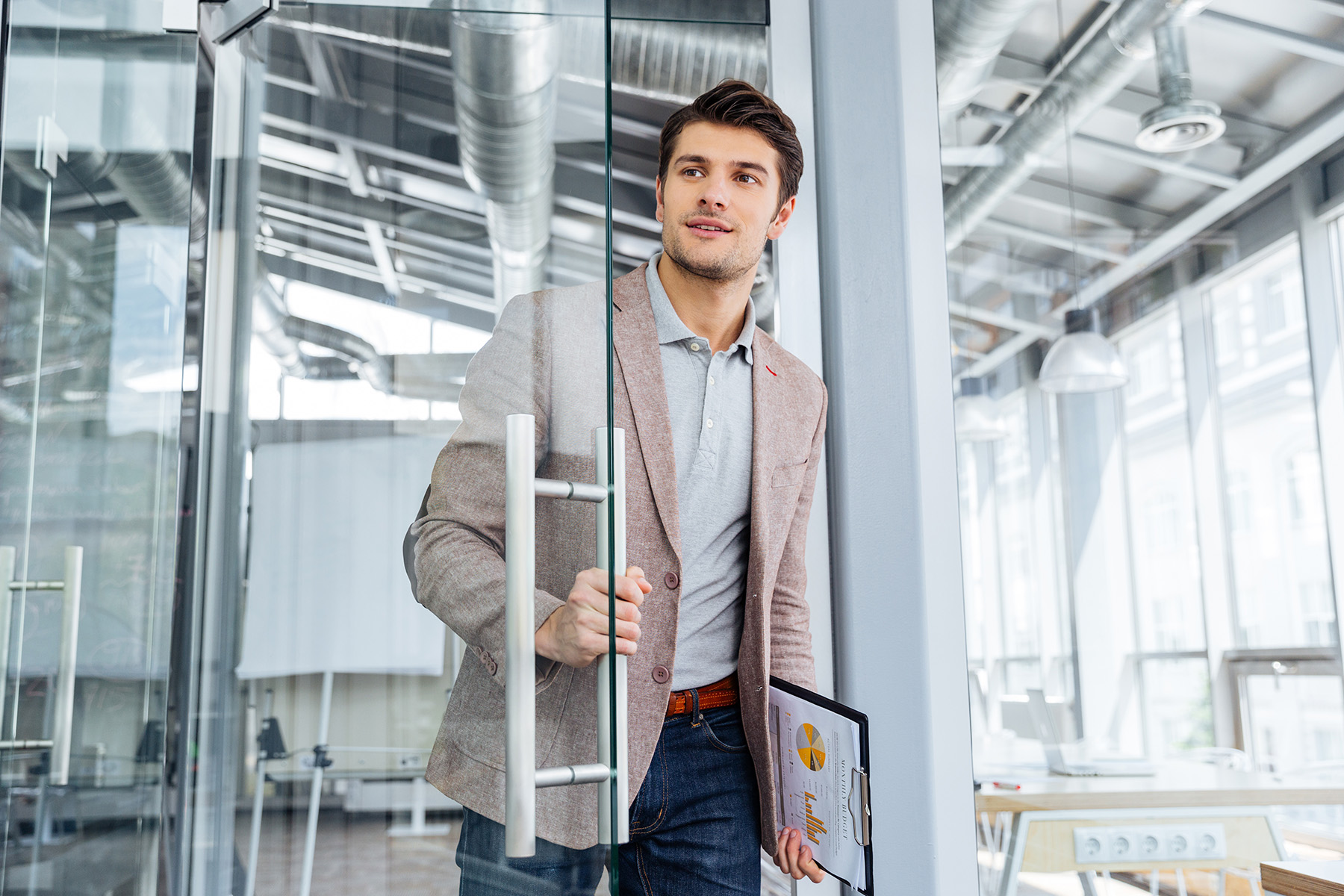 Professional man entering a modern office holding a clipboard, symbolizing confidence, career transition, and new job opportunity.